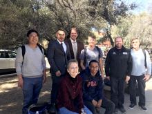 Don Ahrens and Juan Estrada take a photo with students on the UA campus
