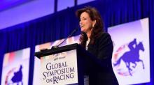 Janet VaBebber stands at podium, during the 2017 Global Symposium on Racing