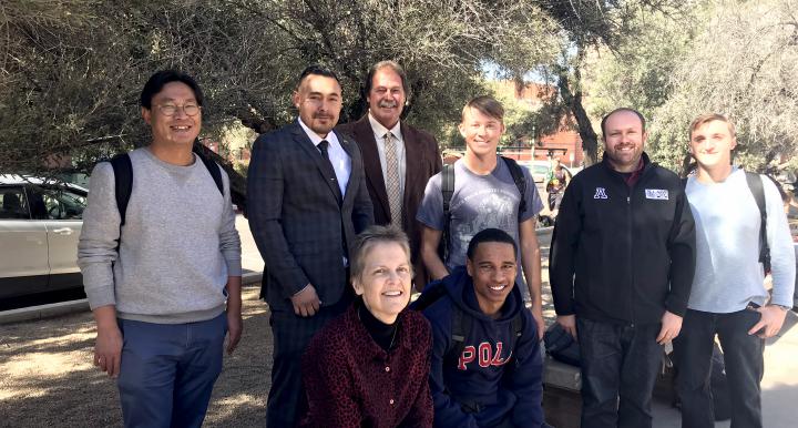 Don Ahrens and Juan Estrada take a photo with students on the UA campus